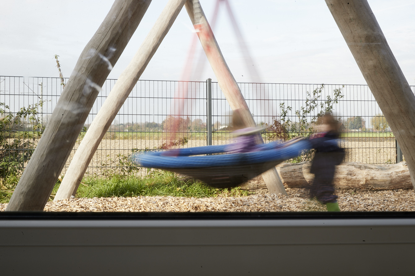 Zwei Kinder spielen auf einer großen Schaukel, die Gesichter sind verschwommen. (Foto: LWL / Haslauer)