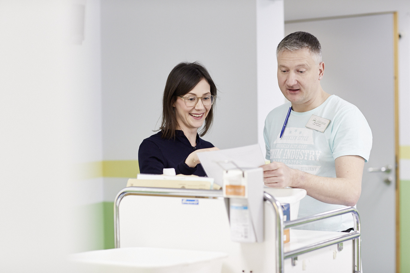 Jobcoach Marie-Theres Hübner und Altenpfleger Mark Prosser im Seniorenheim in Recklinghausen. Beide schauen auf den Arbeitsplan des Tages. Bild: LWL