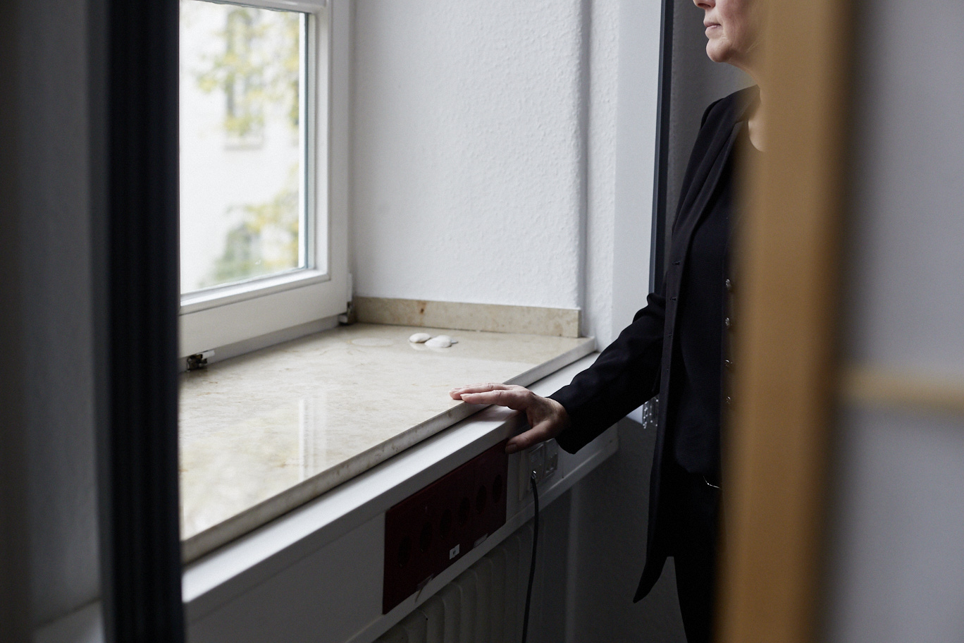 Eine Frau steht an einem Fenster.