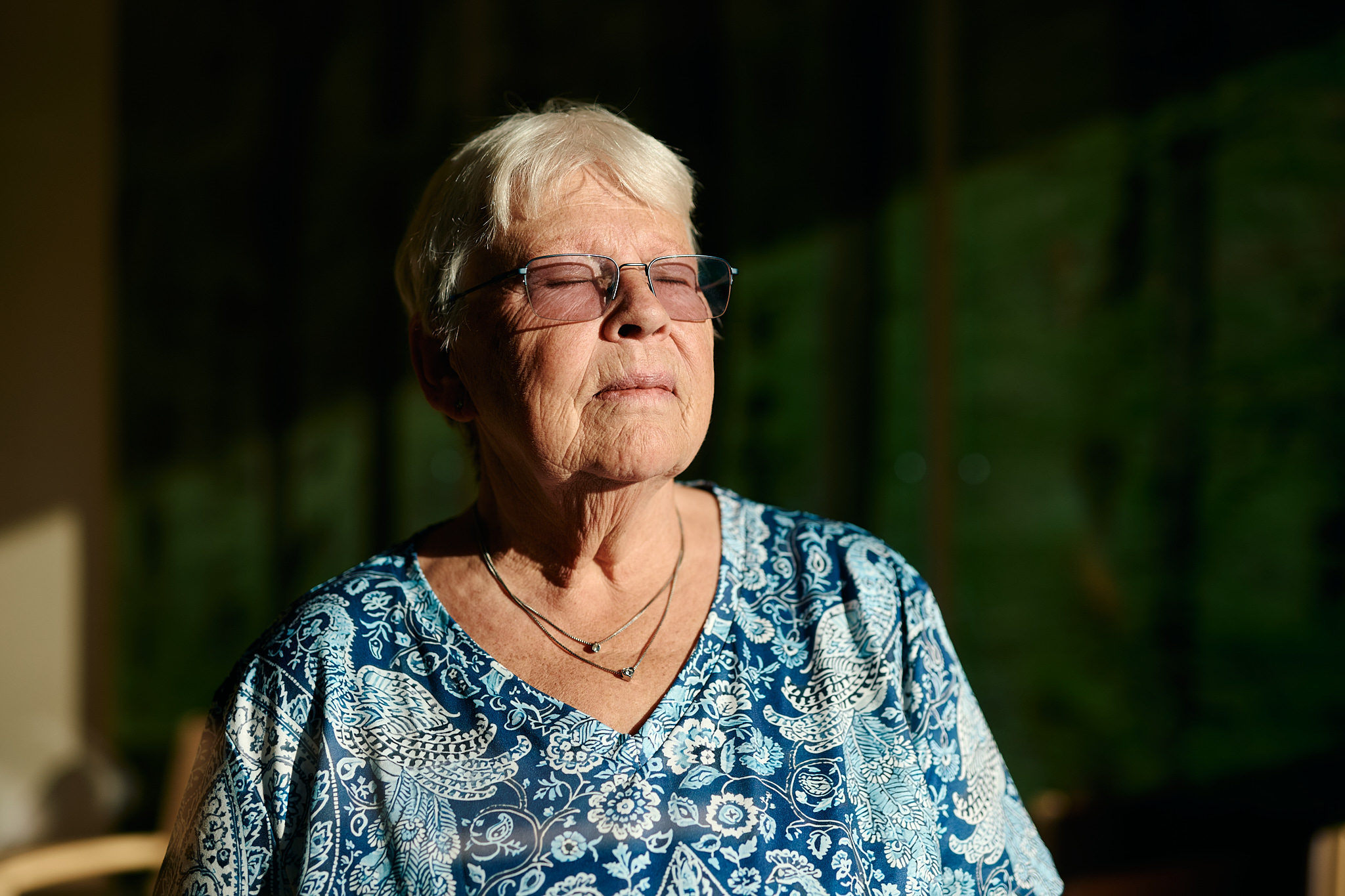 Eine Frau schaut mit geschlossenen Augen ins Licht