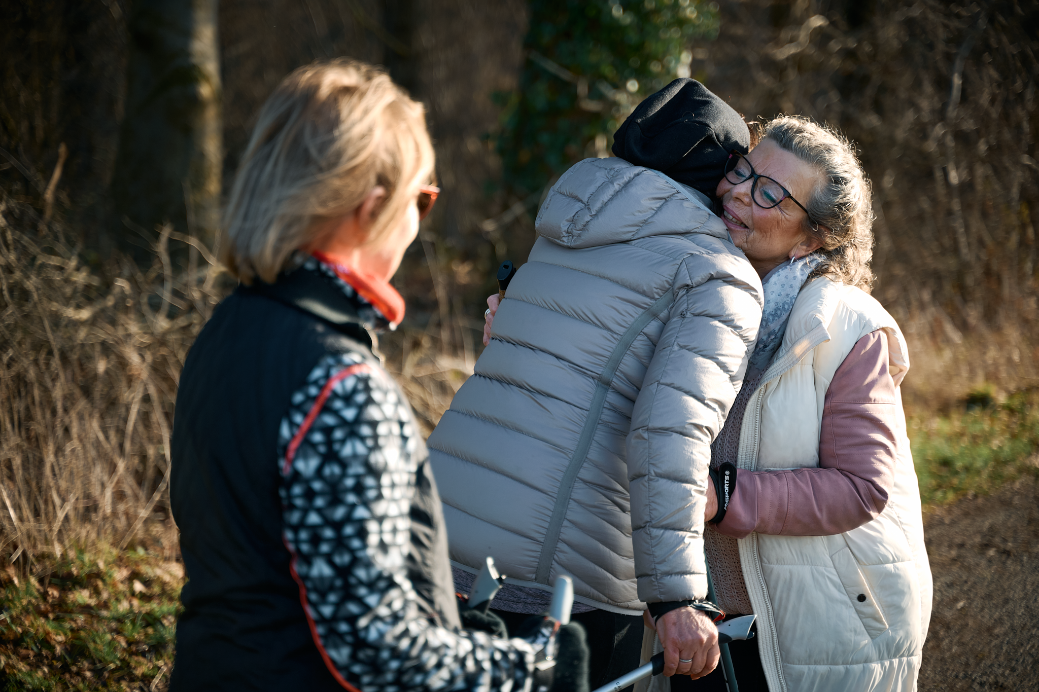 Drei Frau begrüßen sich herzlich.