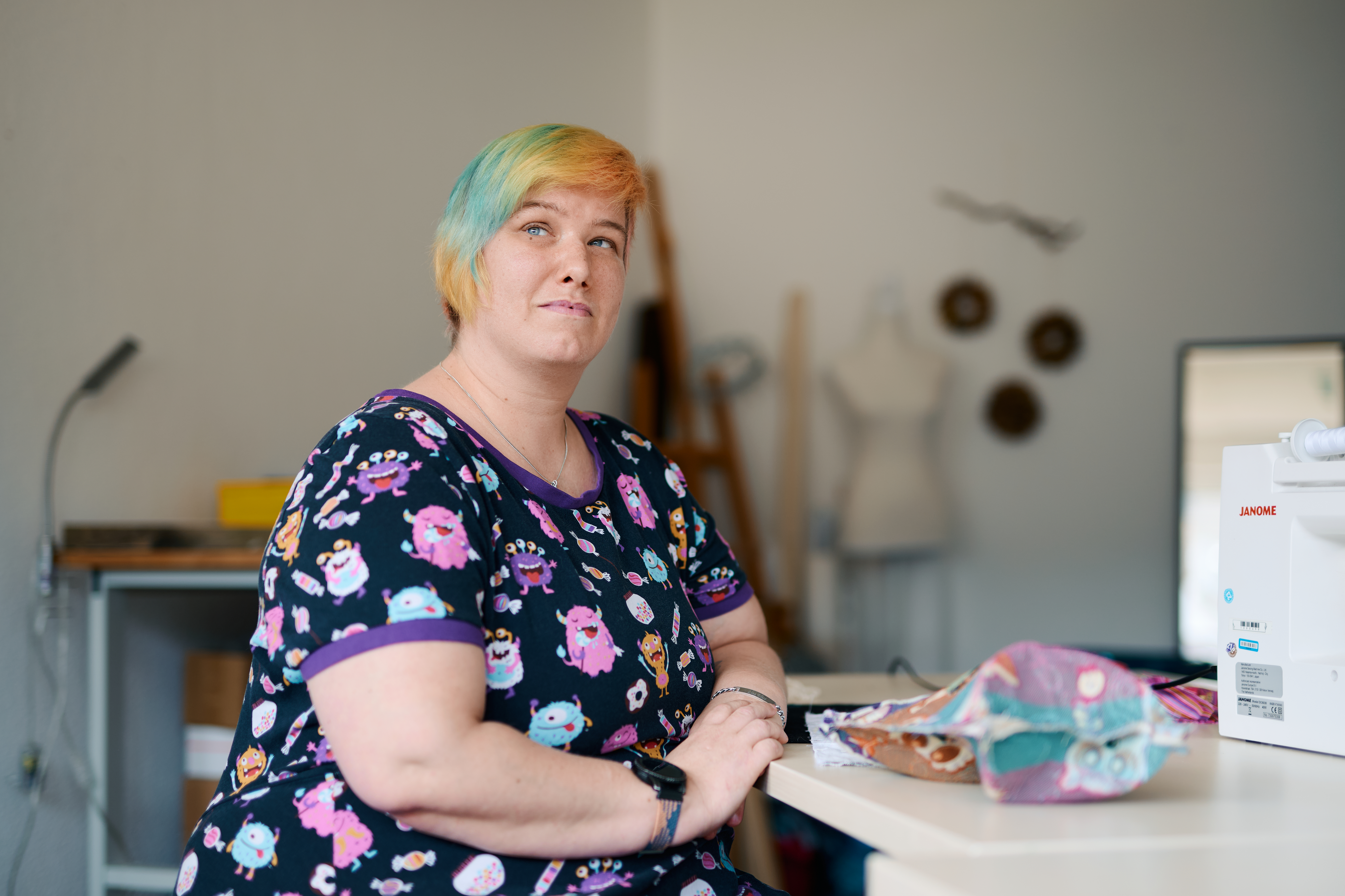 Sanja Lange sitzt am Tisch in der Nähwerkstatt.