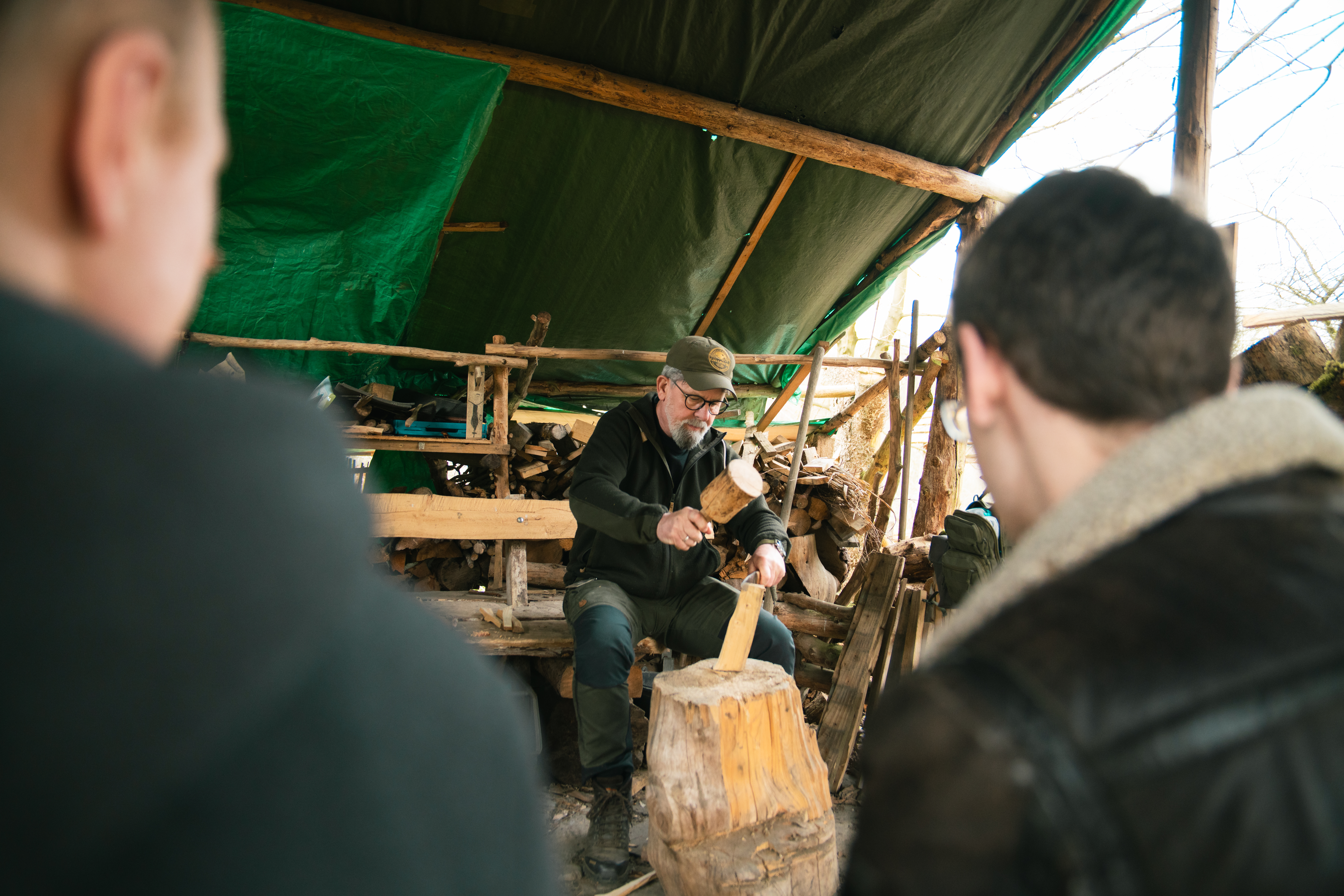 Der Wildnispädagoge macht ein Feuer im Waldlager.