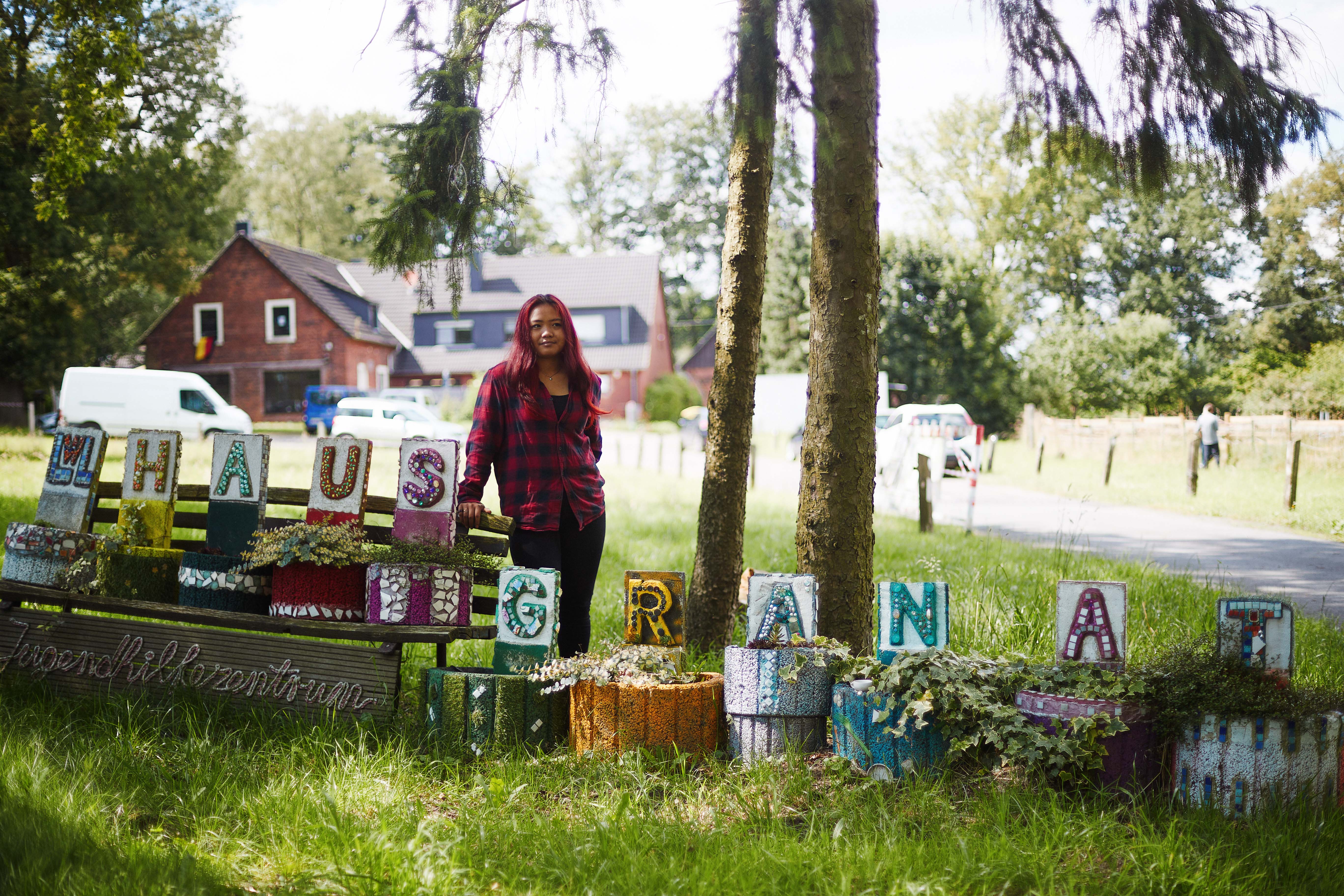 Pat vor Haus Granat, im Vordergrund Buchstaben
