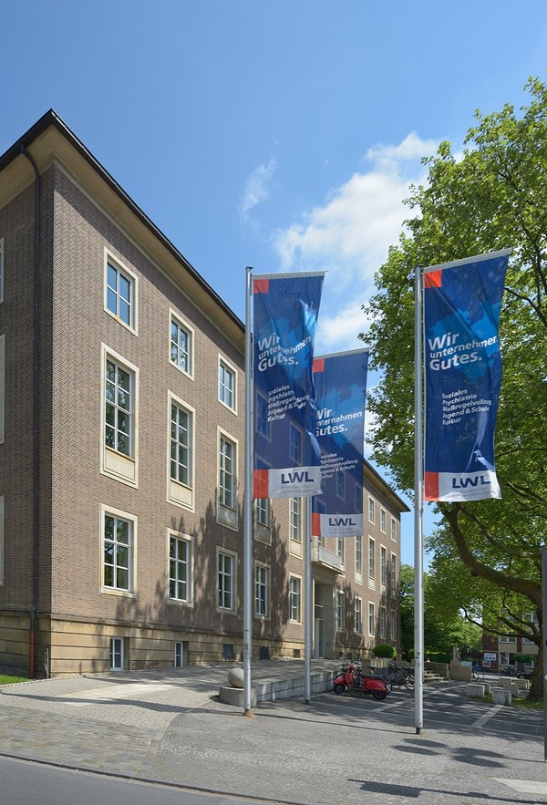 Die Flagen vor dem Landeshaus zeigen den Slogan des LWL: Wir unternehmen Gutes.