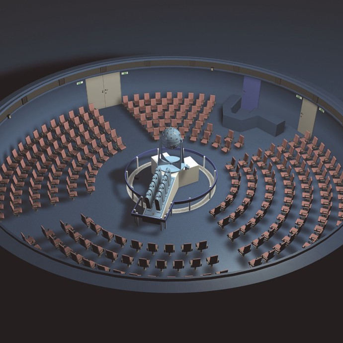 Blick von oben auf den Saal des Planetariums. In der Mitte steht der Projektor und außenherum sind Sitzmöglichkeiten im Kreis aufgestellt. (öffnet vergrößerte Bildansicht)