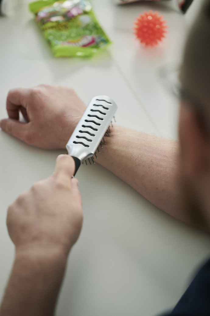 Ein Mann bürstet seinen Unterarm mit einer Haarbürste