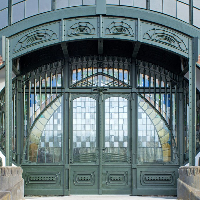 Ein großes Tor einer alten Industriehalle mit Mosaik-Fenstern (vergrößerte Bildansicht wird geöffnet)