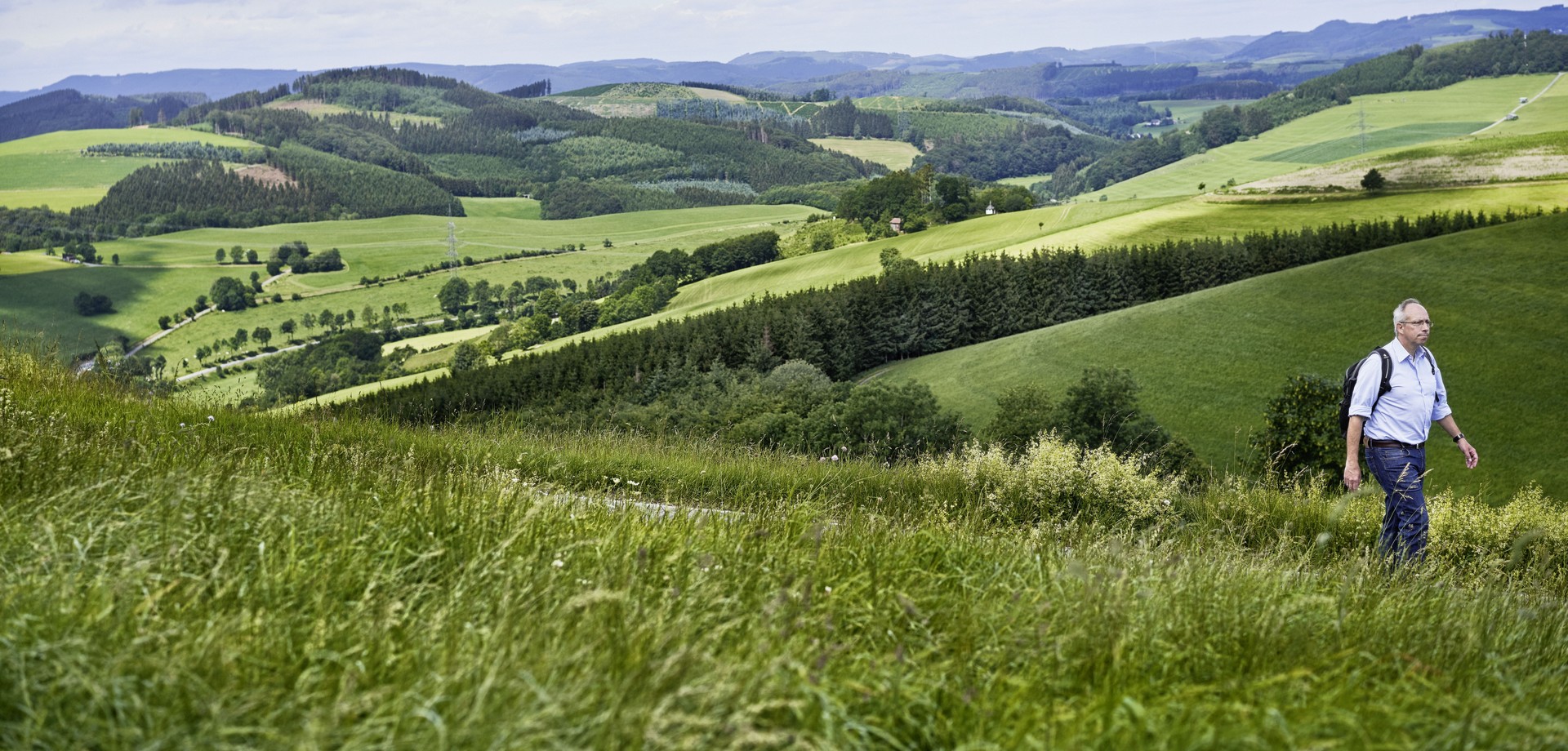 Panoramablick über ein Tal und die Hügelige Landschaft mit dem LWL-Direktor im Vordergrund.