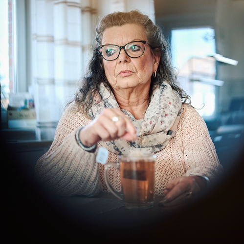 Eine Frau rührt mit einem Teebeutel in einer Tasse