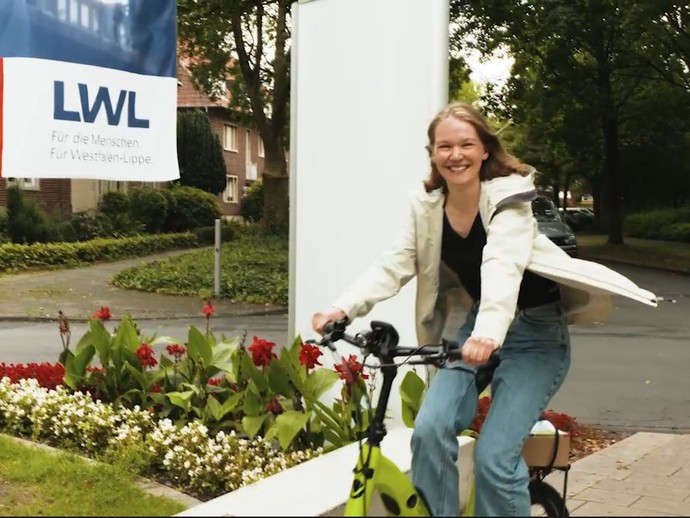 Eine Frau fährt auf einem Fahrrad (öffnet vergrößerte Bildansicht)