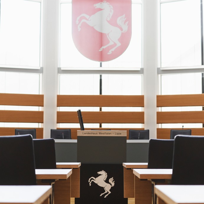 Leerer Plenarsaal mit Rednerpult und Wappen von Westfalen-Lippe. (vergrößerte Bildansicht wird geöffnet)