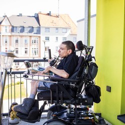 Marc Szykowiak sitzt im Rollstuhl auf seinem Balkon.
