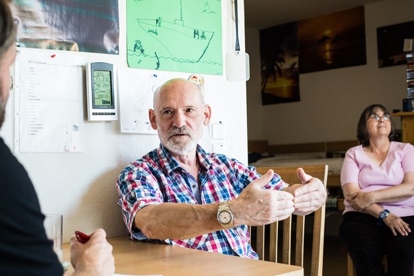 Marcs Vater im Gespräch mit seinem Sohn, beide sitzen am Küchentisch. (Bild: LWL/Steffen)