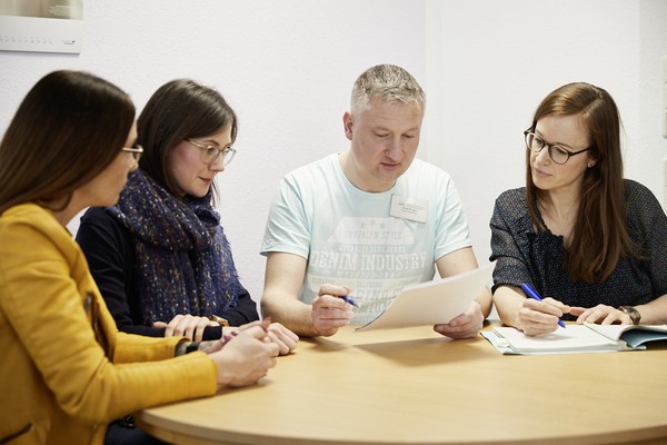 Jobcoach und Mitarbeiter und Mitarbeiterinnen tauschen sich aus.