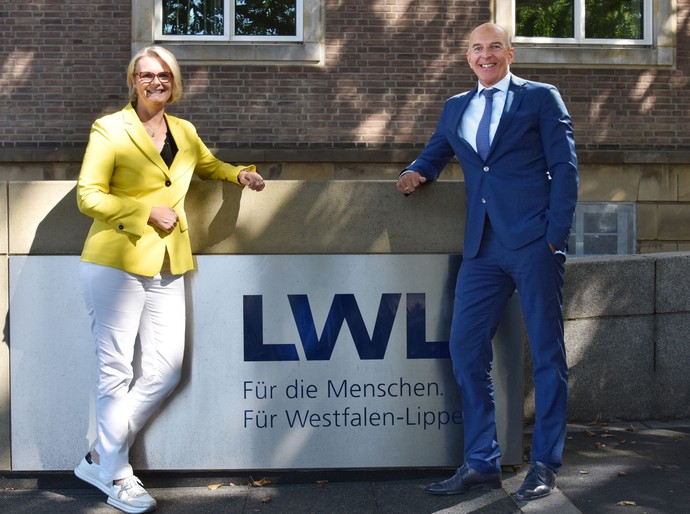Anja Karliczek und Dr. Georg Lunemann vor einem LWL-Schild
