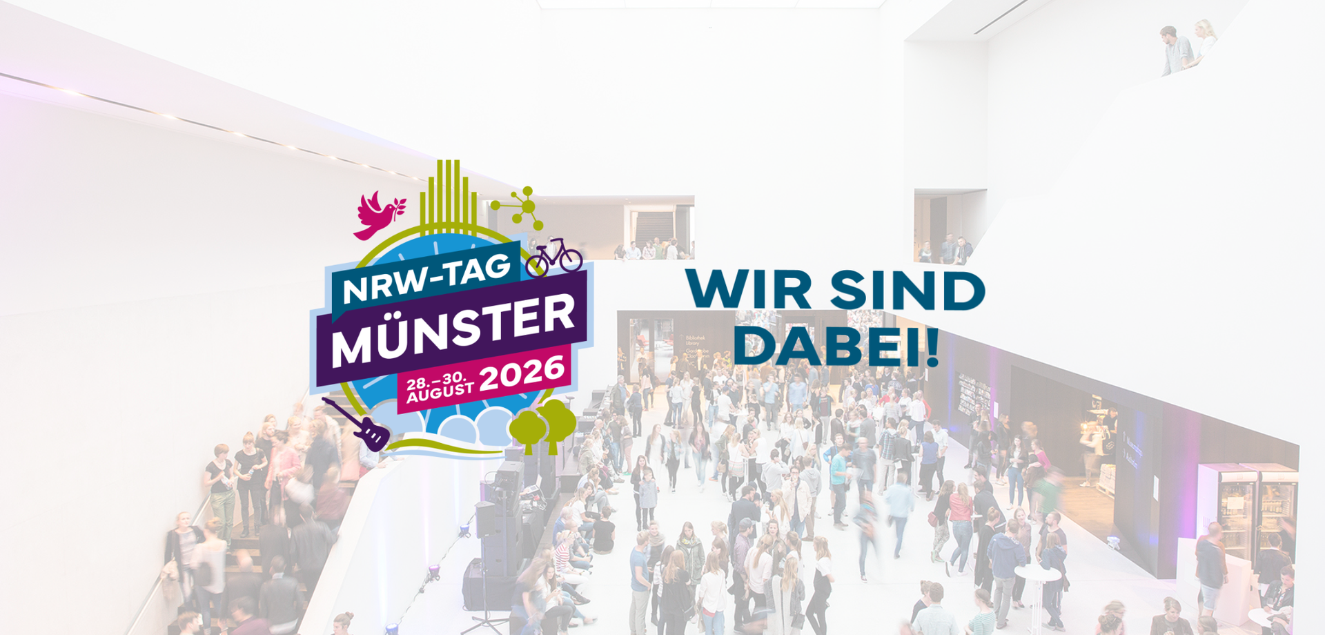 Das Foyer im Museum mit vielen Menschen belebt, davor Logo des NRW-Tag 2026 in Münster.